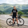 Woman wearing the black Break the Rules graphic tee standing with a bicycle