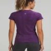 Fitness_model_posing_in_studio_2K_20261018191217 Fitness model wearing the purple Lululemon Swiftly Tech shirt in the studio