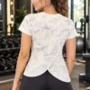 Back view of the Aura Luxe floral performance short-sleeve tee showing the overlapping wrap-style back hem Back view of the Aura Luxe floral performance short-sleeve tee showing the overlapping wrap-style back hem
