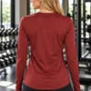 Back view of the pre-loved rust red Xersion long-sleeve tech tee with curved hem Back view of the pre-loved rust red Xersion long-sleeve tech tee with curved hem